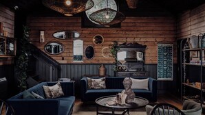 A cozy room with a dark blue sofa, a round coffee table, and wicker pendant lights. - Ship Inn Stanley (Stanley)