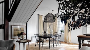 A dining area with a round table, black chairs, and a hanging light fixture. - Ship Inn Stanley (Stanley)
