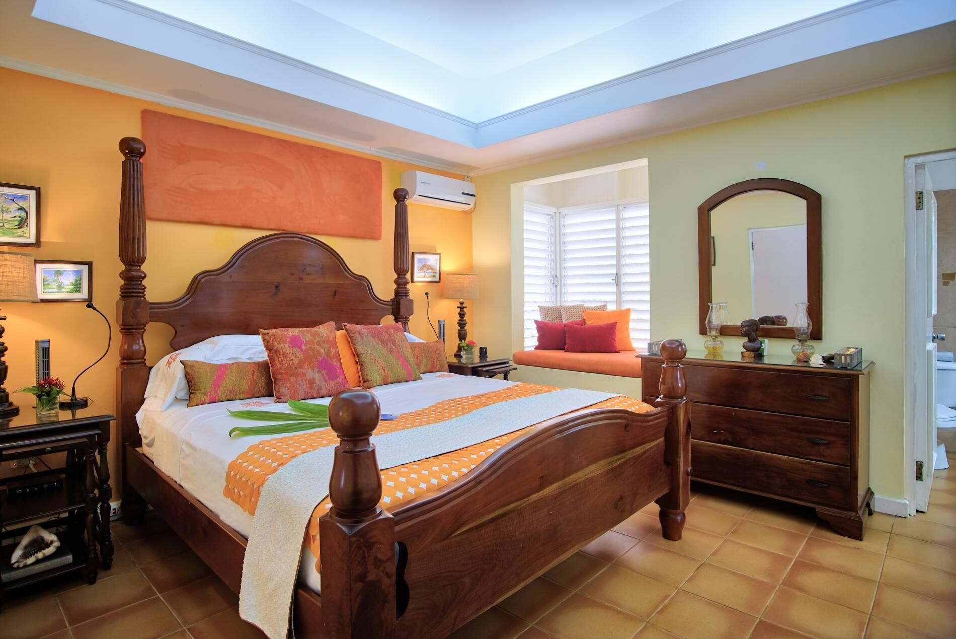 A bedroom with a wooden bed, a nightstand, a dresser, and a window with blinds.