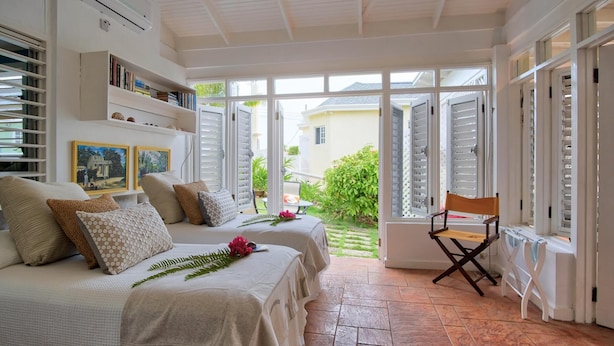 A room with a bed, a chair, and a window.