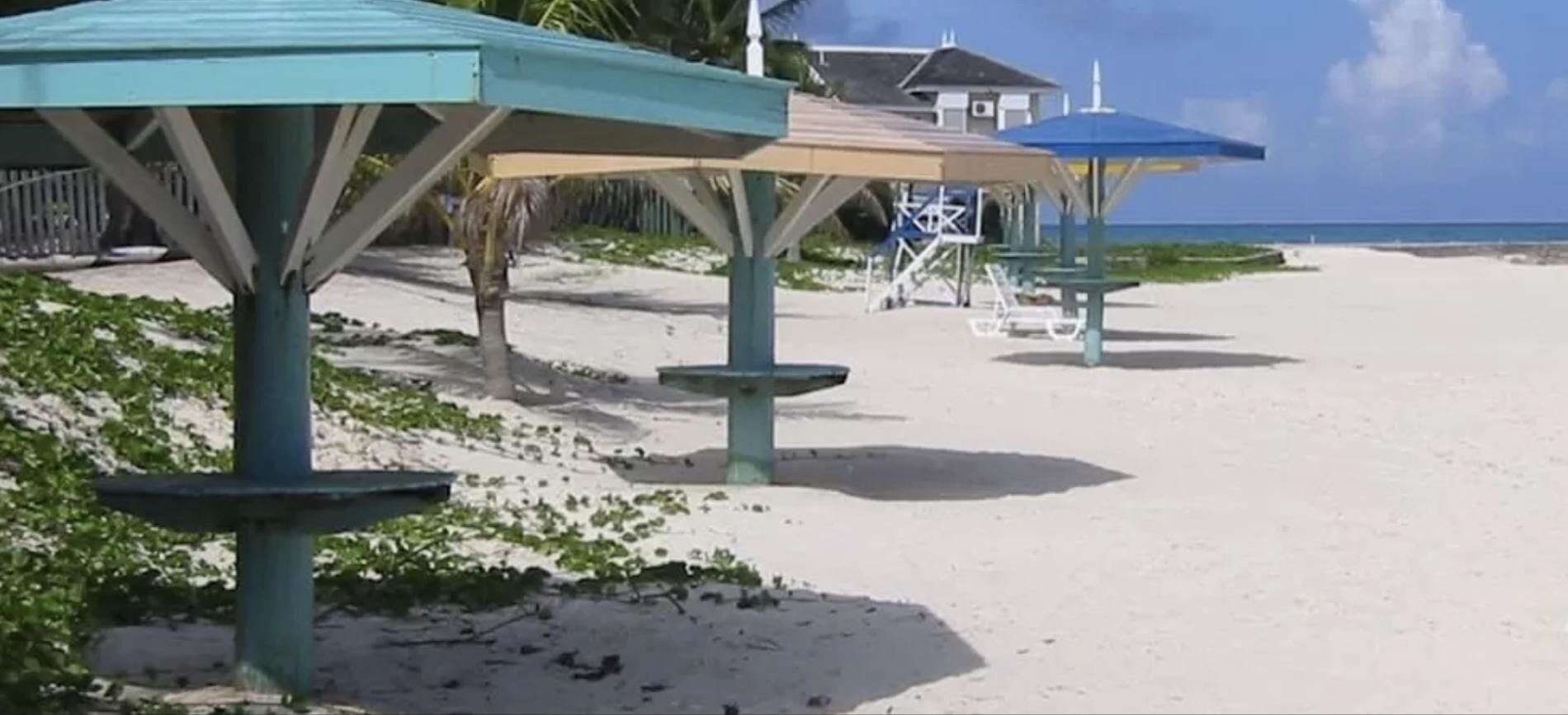 Une plage avec plusieurs parasols et une tour de surveillance des sauveteurs.