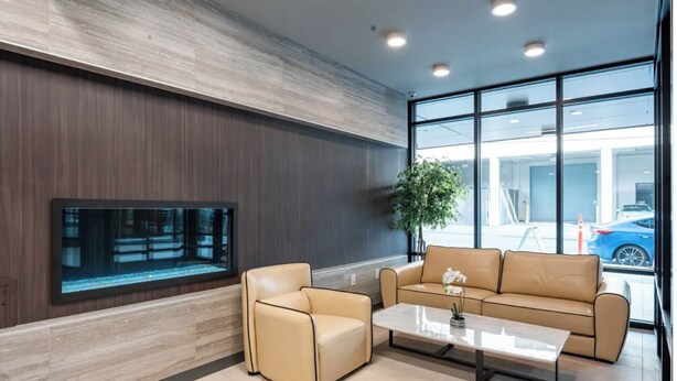 A modern lobby with a large fish tank, leather seating, and a view of the parking area. - Modern Studio Steps to UW (Seattle)