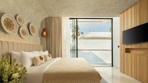 Een moderne slaapkamer met een groot bed, een flatscreen televisie en een balkon met uitzicht.