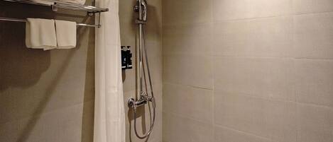 Un baño moderno con ducha, inodoro y barra para toallas.