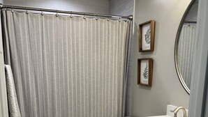 Une salle de bain avec des toilettes, un lavabo et un rideau de douche.