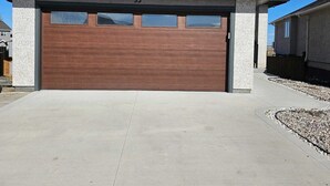 Uma casa moderna de dois andares com garagem número 35, um caminho de acesso de concreto e um céu azul límpido.