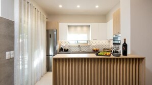 Une cuisine moderne dotée d’un îlot central, d’appareils électroménagers en acier inoxydable et d’une fenêtre offrant une belle vue.