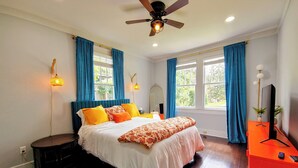 A bedroom with a bed, a ceiling fan, a nightstand, a dresser, and a TV. - 3-bedroom in Mid City, walking distance to LSU lakes, Garden District (Baton Rouge)