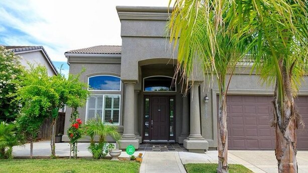 A residential house with a front entrance, a garage, and a well-maintained lawn. - Spacious 5-bedroom house in delightful Elk Grove with AC, WiFi,fitness equipment (elk grove)