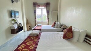 A hotel room with two beds, a TV, a fan, and a window with curtains. - Sky Hotel Moc Chau - by BAY LUXURY (Moc Son)