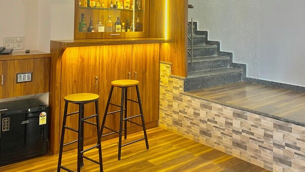 Un'area bar con un bancone in legno, sgabelli e una scala.