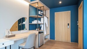 Une chambre moderne avec un bureau en bois, une chaise, une armoire intégrée et une porte.