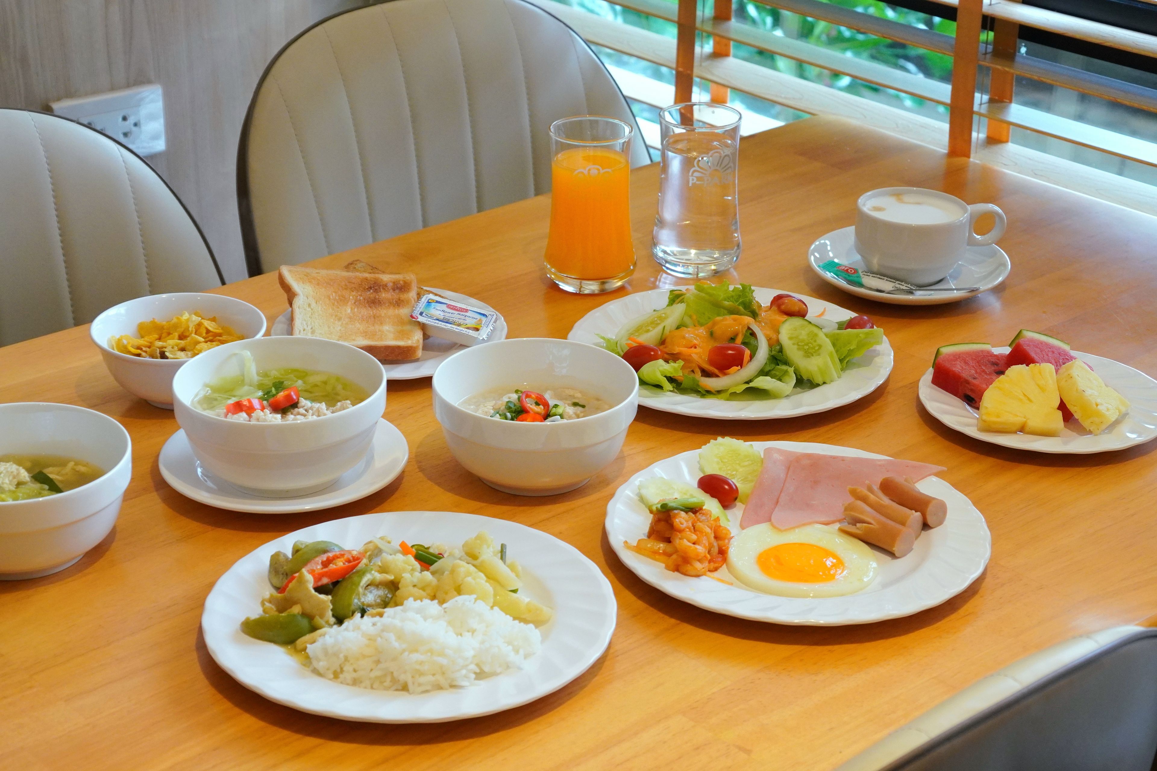 A dining table with various dishes including rice, soup, and a salad.