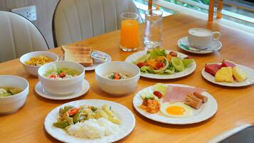 A dining table with various dishes including rice, soup, and a salad.