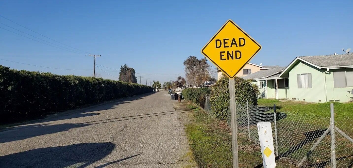 A residential street with a 'DEAD END' sign.