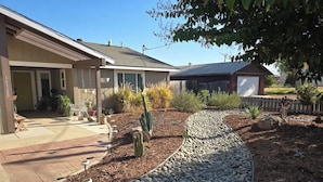 A residential property with a paved driveway, a cactus in the garden, and a wooden fence. - Home Among the Orchards, Pool, National Parks, Friendliest of Towns (Exeter)
