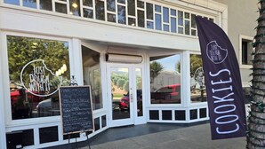 A bakery with a sign reading "Just Dough With It" and a banner for cookies. - Home Among the Orchards, Pool, National Parks, Friendliest of Towns (Exeter)