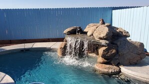 A swimming pool with a waterfall feature and rocks. - Home Among the Orchards, Pool, National Parks, Friendliest of Towns (Exeter)