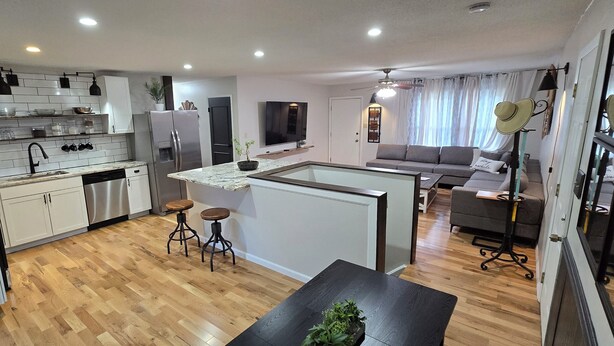 Ein kompakter Wohnraum mit Küche, Essbereich und Sitzgelegenheit.