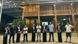 A group of people standing in front of a building with a wooden facade and a balcony. - Doi Thong Moc Chau - by BAY LUXURY (Moc Son)