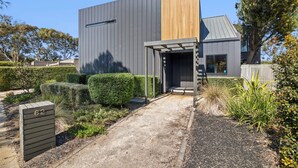 A modern building with a grey facade and a wooden section.