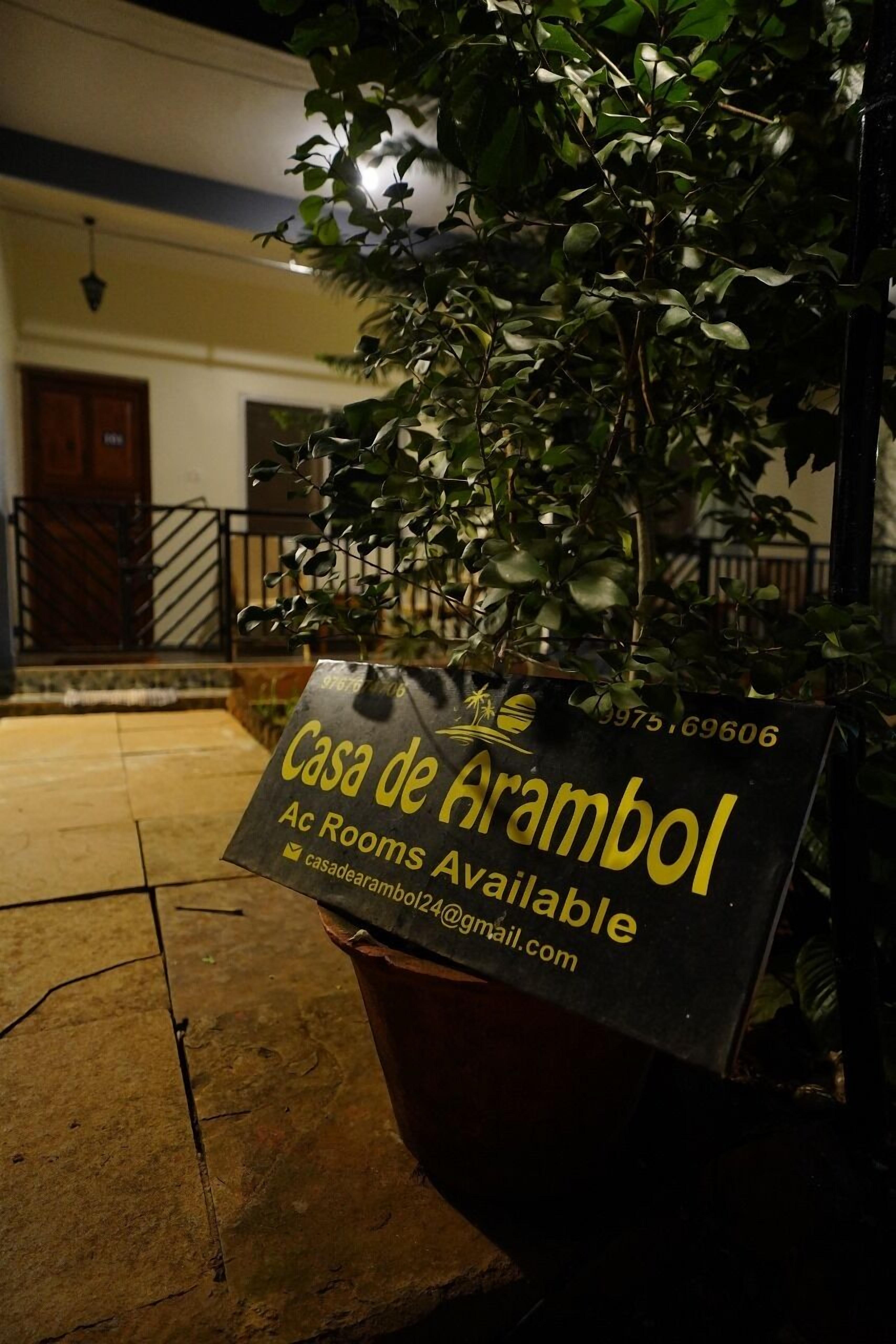 A sign for Casa de Arambol with contact information and an email address.