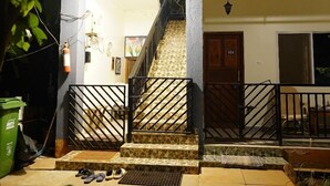 Une cour intérieure avec un escalier en pierre menant à un balcon situé au deuxième étage.