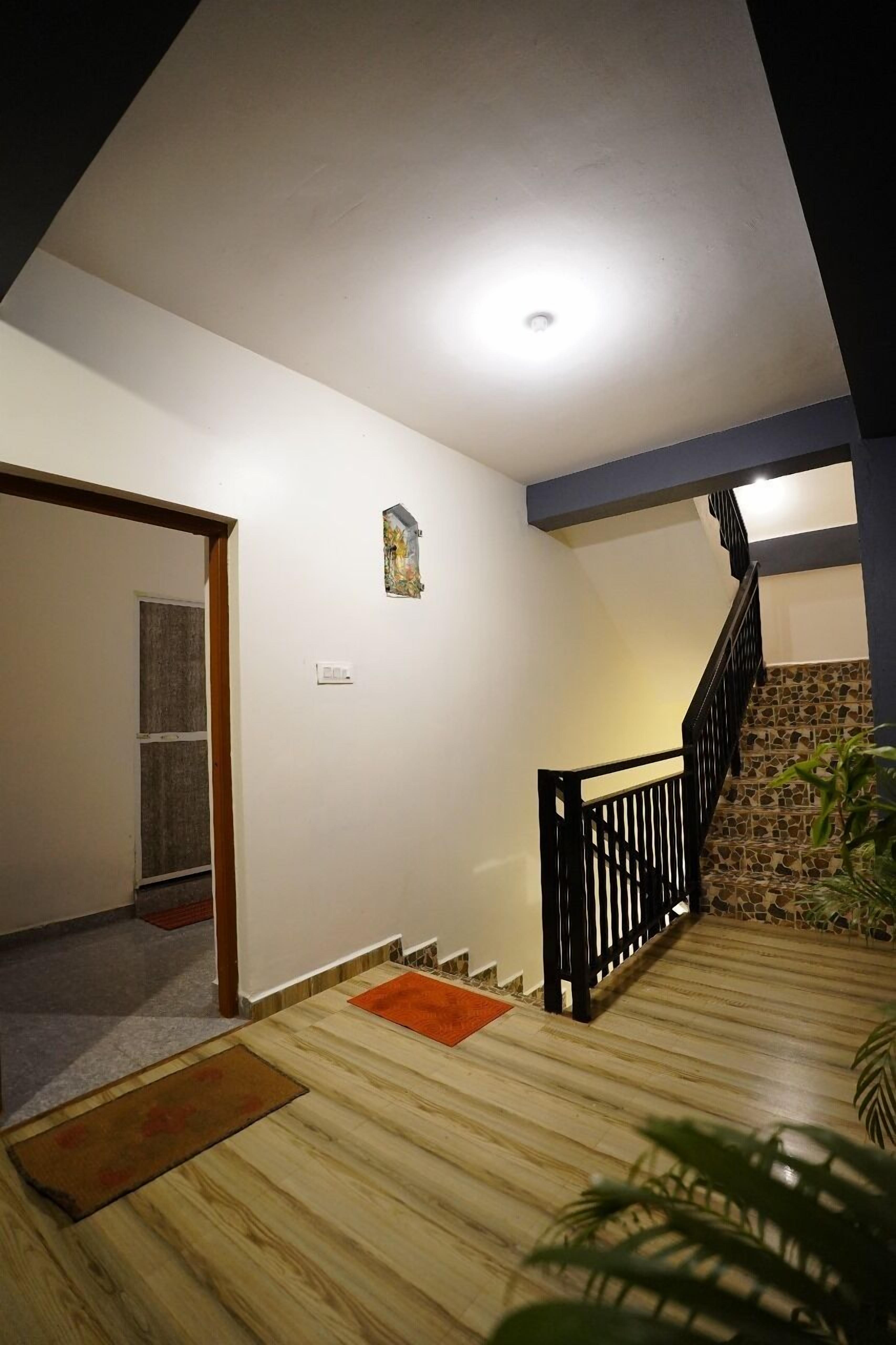 A staircase with a wooden floor and black railing, leading to a lower level.