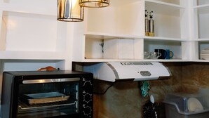 Een keuken met een ingebouwde oven, een fornuis en hangende pendelverlichting.