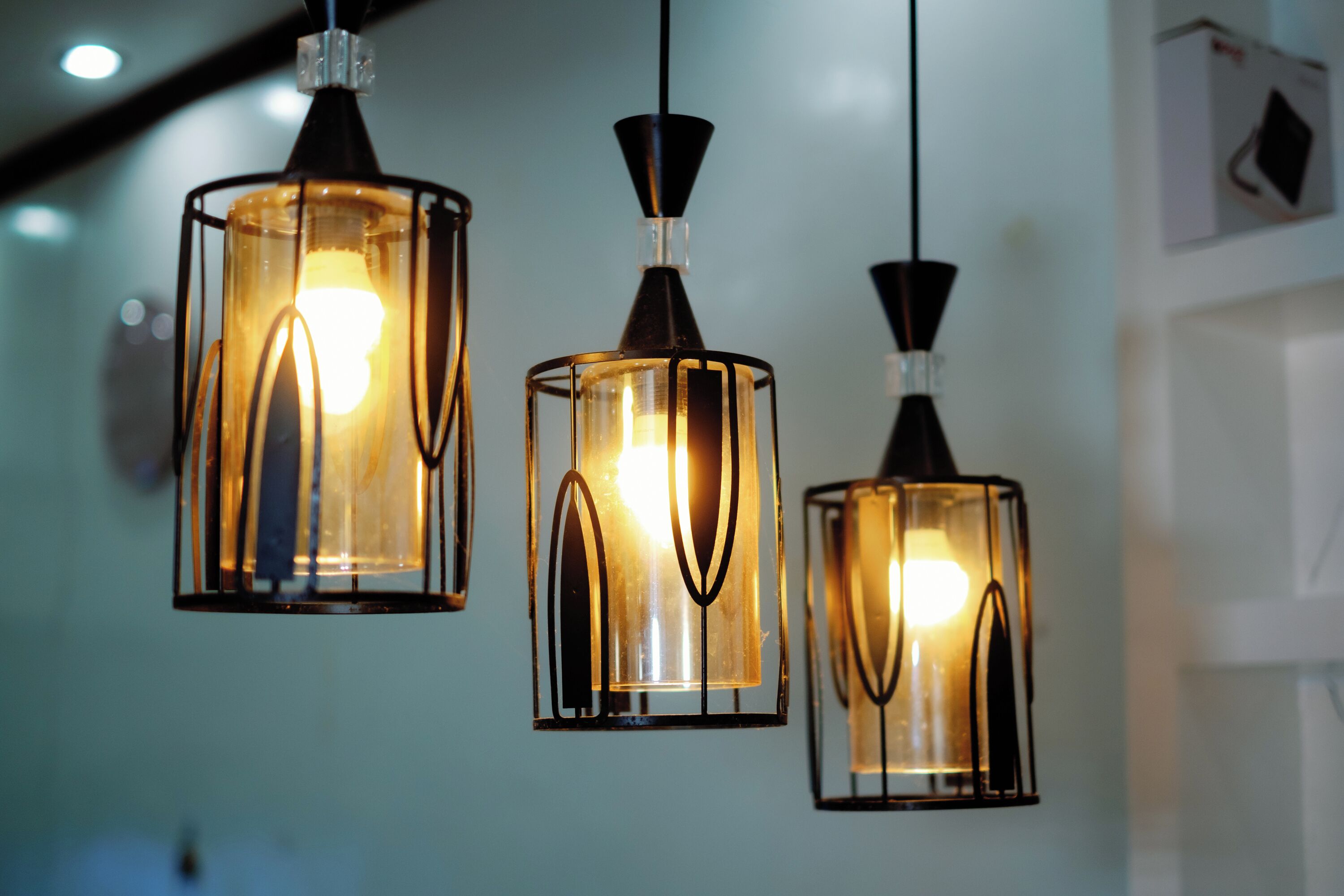 Tres lámparas colgantes de diseño moderno, suspendidas del techo en una habitación bien iluminada.