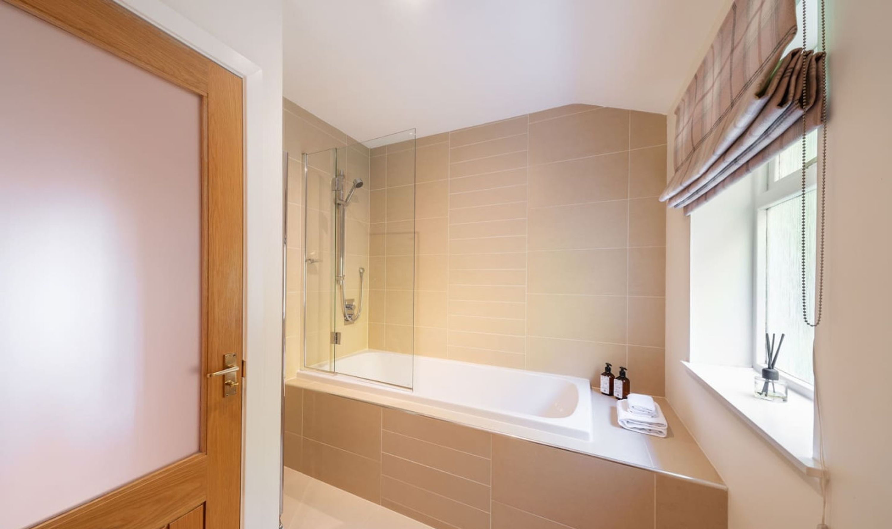 Une salle de bain moderne avec une douche à parois de verre, une baignoire sur pieds et une fenêtre avec des rideaux.