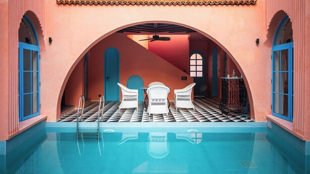 A pool area with a checkered floor, white chairs, and a blue door. - Casa Amore Baia (Mandrem)