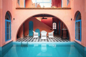 A pool area with a checkered floor, white chairs, and a blue door. - Casa Amore Baia (Mandrem)