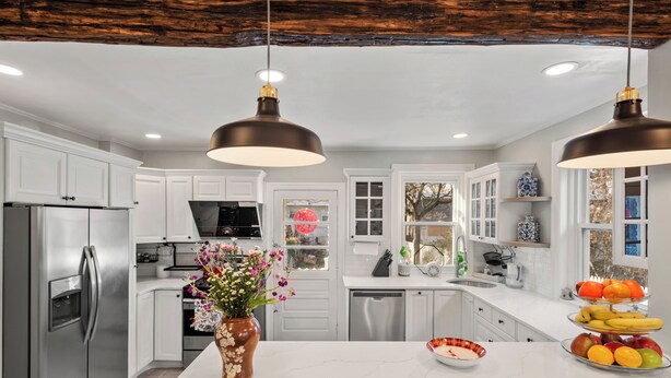 A modern kitchen with white cabinets, stainless steel appliances, a marble island, and pendant lighting. - Sophia's Garden Cottage-  Quality & Stylish & Car-Ps & Walk-Zone & Kid Friendly  (Ardmore)