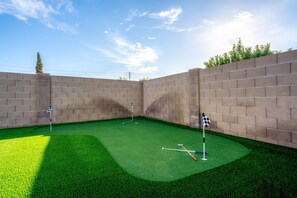 A miniature golf course with artificial turf and brick walls. - Backyard Game Day HQ | Pool, Hoops & Putt Putt (Glendale)
