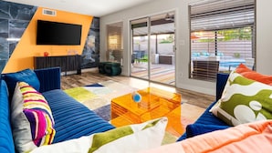 Una sala de estar moderna con un sofá, una mesa de centro y un televisor de pantalla plana montado en la pared.