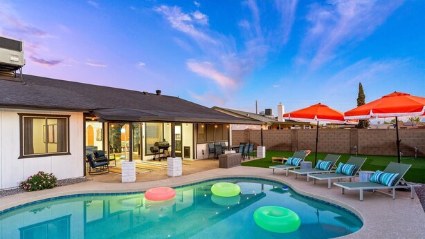 Una casa moderna con piscina, mobiliario exterior y zona de patio.