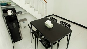 Eine kleine Küche mit schwarzem Arbeitsplatz, einer Kaffeemaschine und einem Mülleimer.