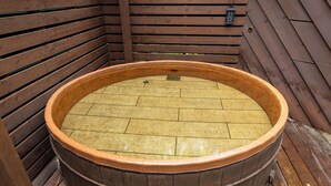 A wooden hot tub with a tiled interior, surrounded by wooden walls and floor. - izukougen no chiisana o-beruju arusion (Ito)