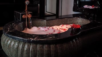 Relax in a spacious bathtub surrounded by a mosaic border and elegant faucet.