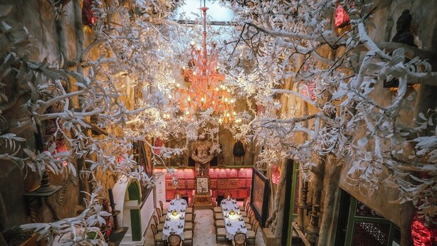 A restaurant with a central dining area, multiple tables, and a chandelier. - House of Tugu Old Town Jakarta (Jakarta)