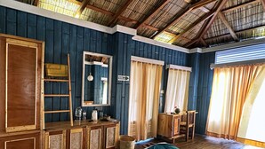 Une pièce avec un lit, des meubles en bois, un miroir et une fenêtre avec des rideaux.