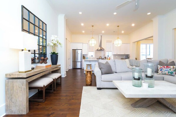 A spacious living room with a sofa, coffee table, and a dining area with a bench.