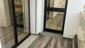 Un interior moderno con una puerta de vidrio que da a un piso de madera.