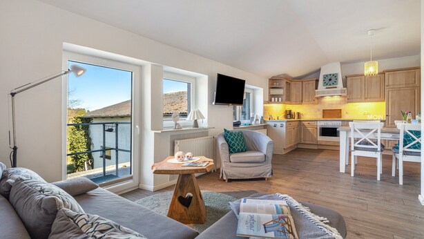 Een modern appartement met woonkamer, keuken en balkon.