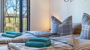 Een hotelkamer met een bed, kussens en een raam.