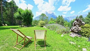 Two wooden chairs in a grassy area with a mountain view. - L'indret del Pedraforca (Saldes)