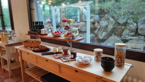 A breakfast buffet with various food items and condiments on a wooden table. - L'indret del Pedraforca (Saldes)