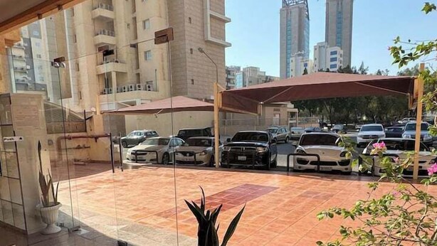 L'ingresso di un hotel con vista su un parcheggio e sugli edifici circostanti.