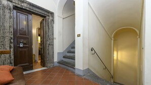 A hotel lobby with a marble reception desk, a staircase, and a golden door. - Cartari Deluxe apartment (Roma)